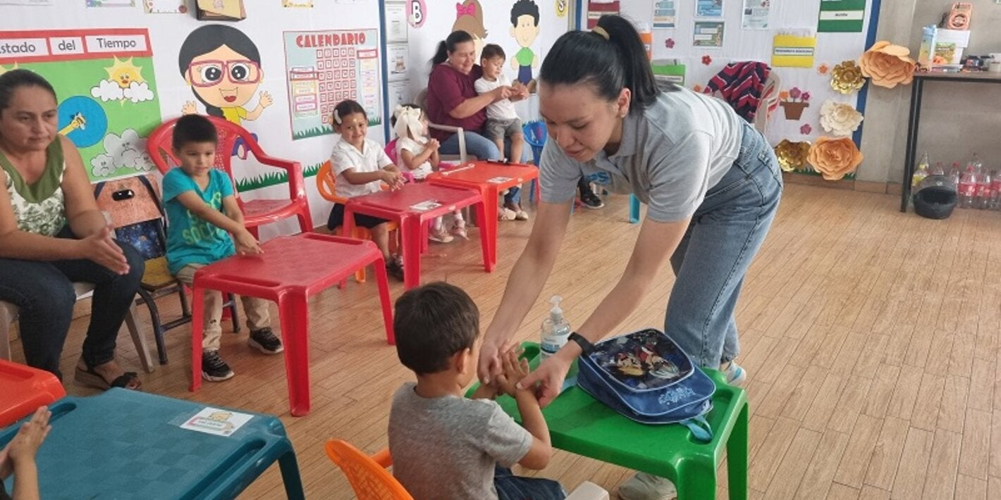 Alejandra Velásquez del proyecto CERF enseña técnica de lavado de manos a niños en Sinuapa, Ocotepeque