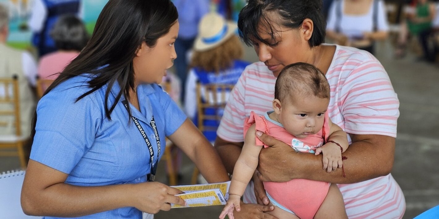 Enfermera junto a madre y niño vacunado
