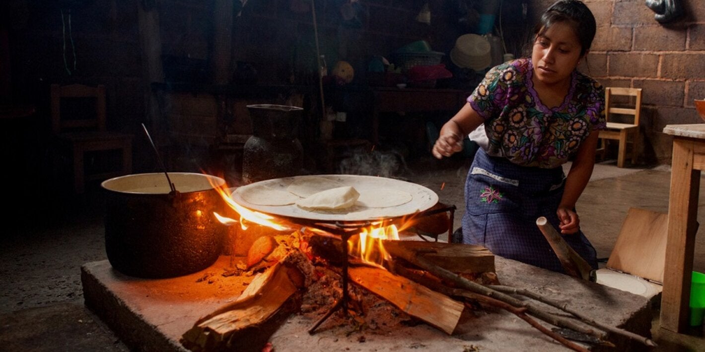 Mujer maya cocinando al fuego