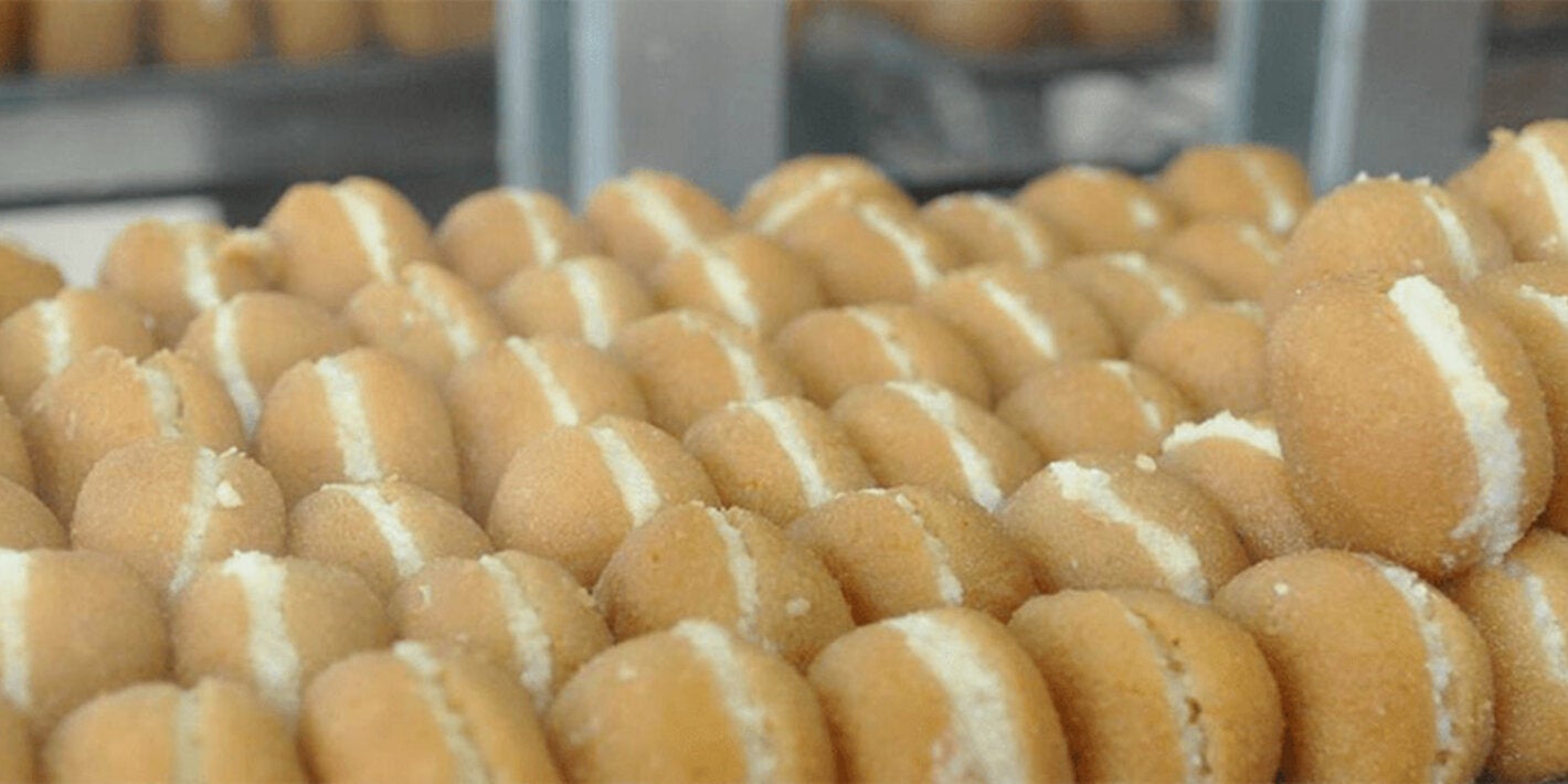 baking sheet full of cream-filled sugar-coated fried pastries