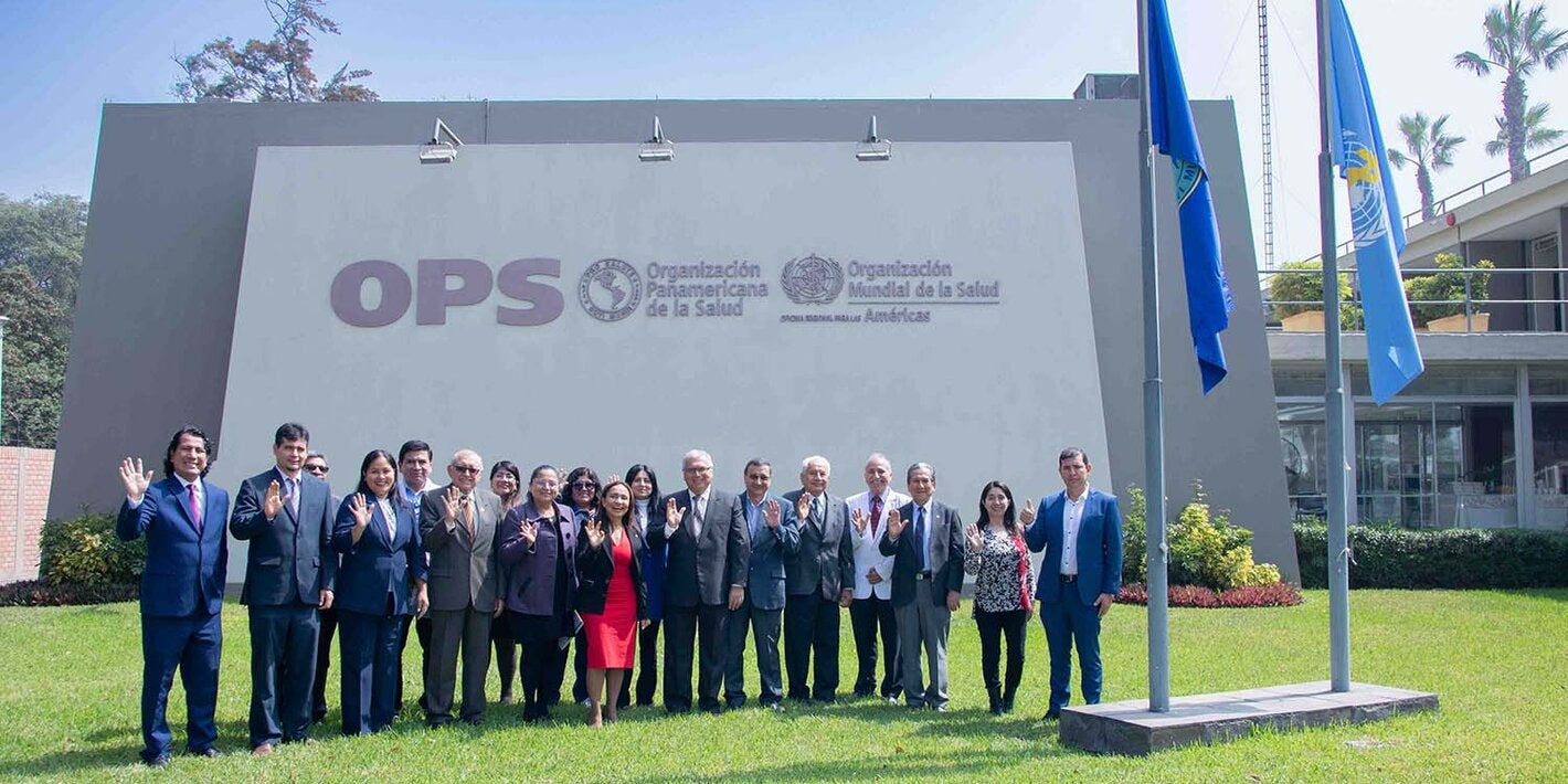 Foto grupal de los miembros del comité y autoridades en la fachada de la OPS Perú
