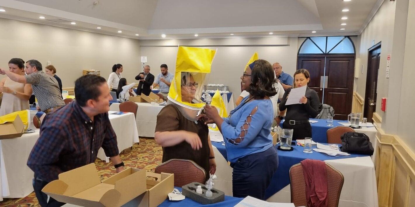Large event room. Participants are learning how to use personal protection equipment on a respiratory protection training