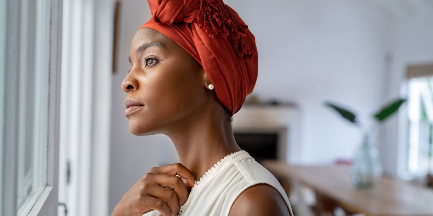 Woman with head turban looking out the window