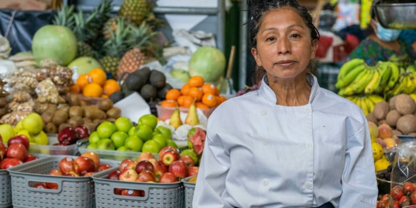 Mujer vende vegetales y frutas en mercado