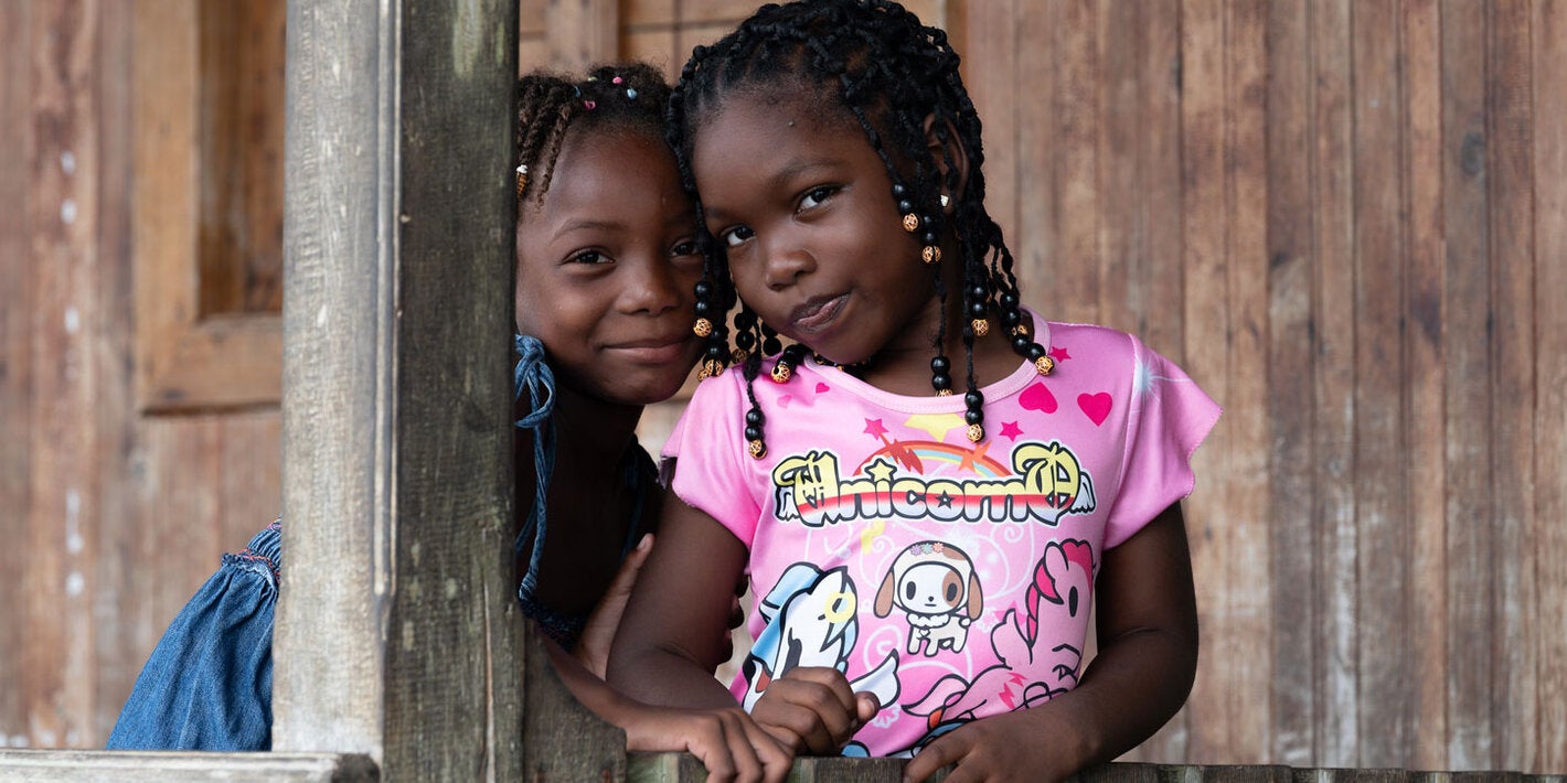 Young girls pose around post