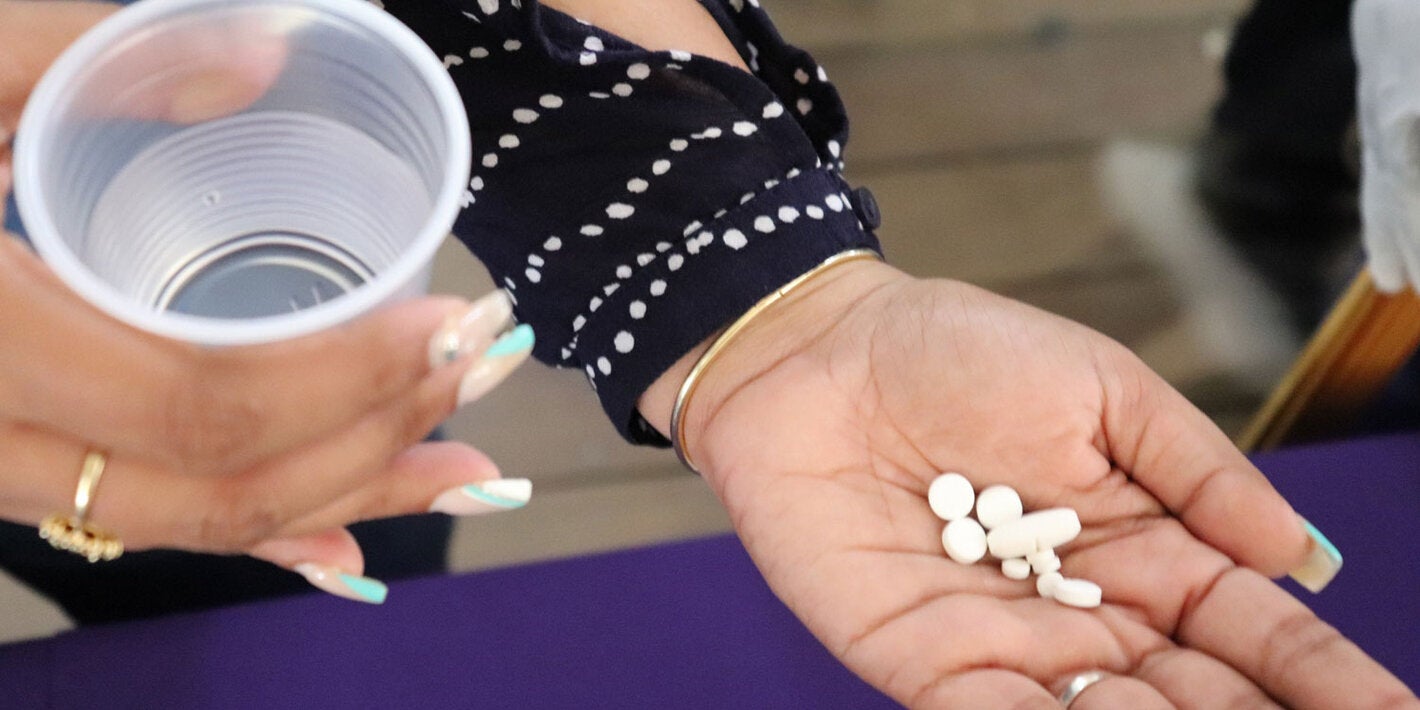 Treatment for lymphatic filariasis. Woman hold pills on her hand.