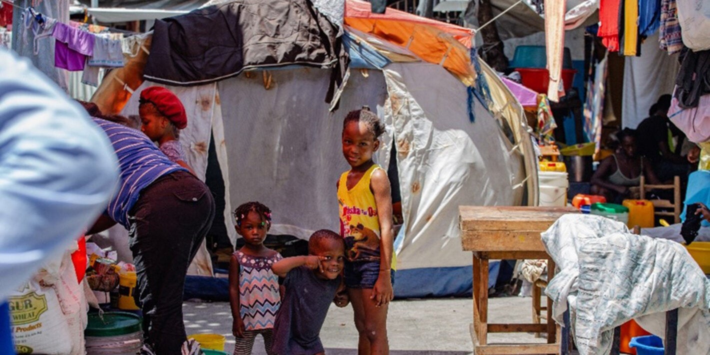 Children smile at camera at a camp in Haiti