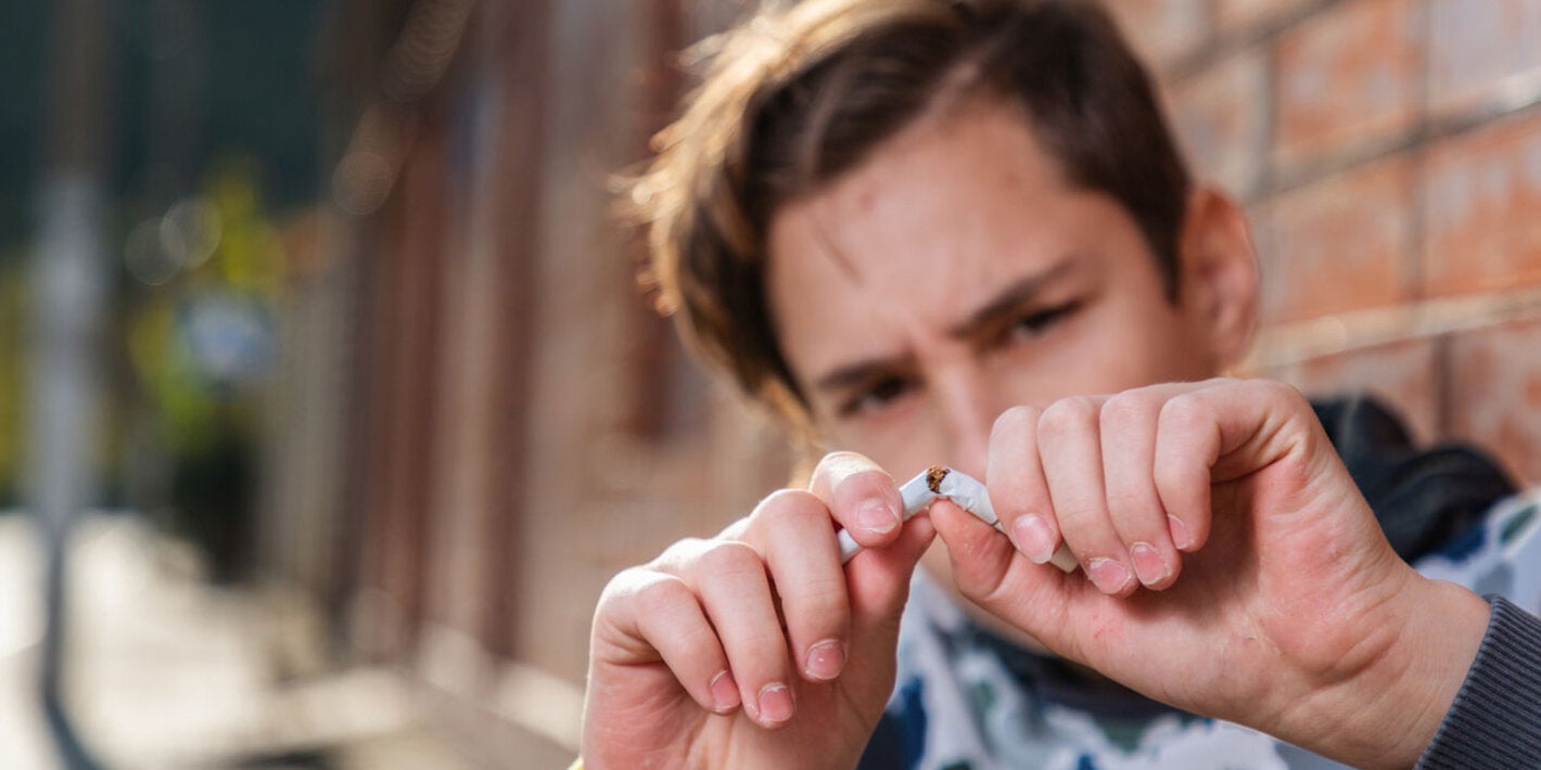 Young man breaking a cigarrette