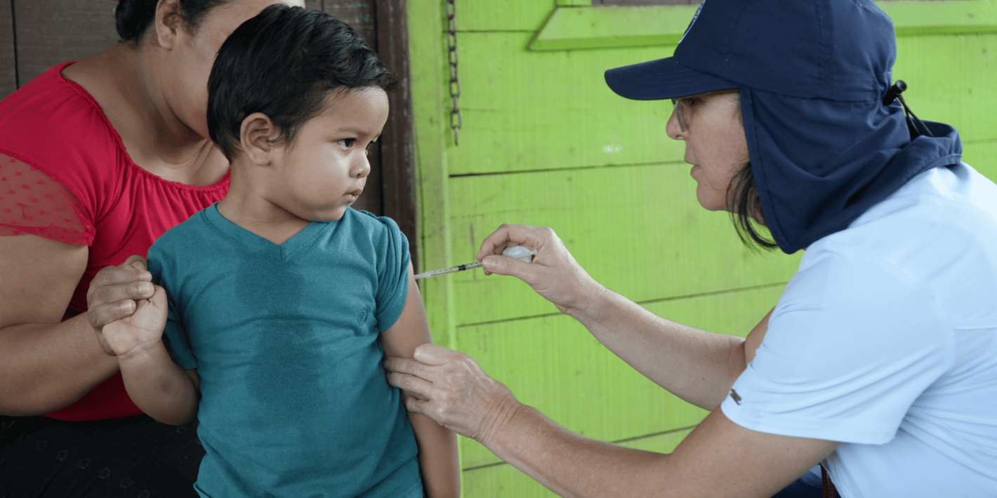 Un niño recibiendo en su casa la dosis pendiente de la vacuna contra sarampión, rubéola y paperas