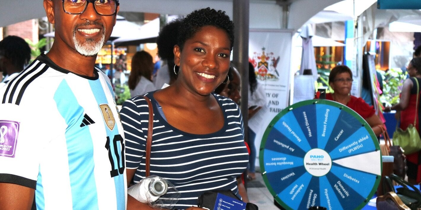 A couple at the PAHO/WHO TTO booth at the UNDP Caravan