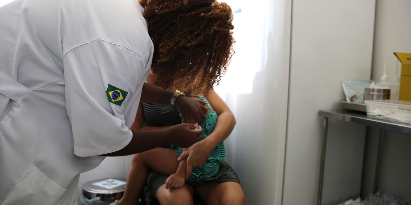 Health worker vaccinates child against yellow fever