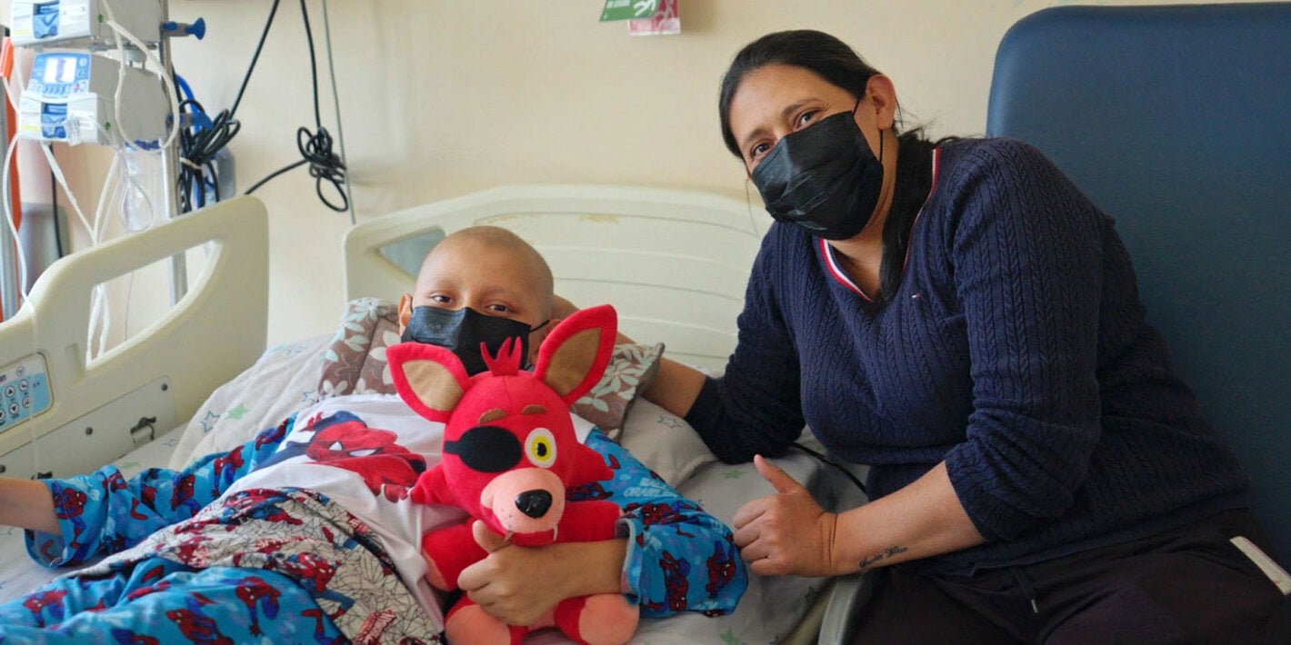 Mãe com filho, que está em uma cama de hospital