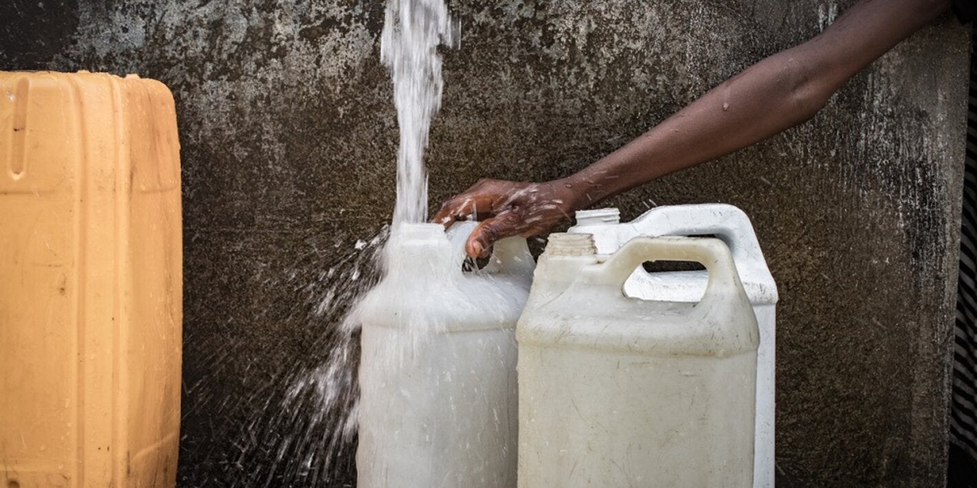 Mujer recogiendo agua en Haití