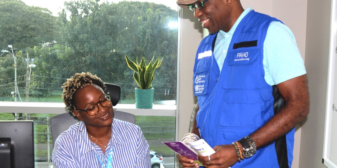 L-R (seated) Dr Ayanna Alexander , Technical Officer - Health Promotion, Life Course, and Determinants and (standing) Dr Stephen Nurse-Findlay, Advisor, Communicable Disease Control and Elimination review the printed Hansen’s disease communication materials.