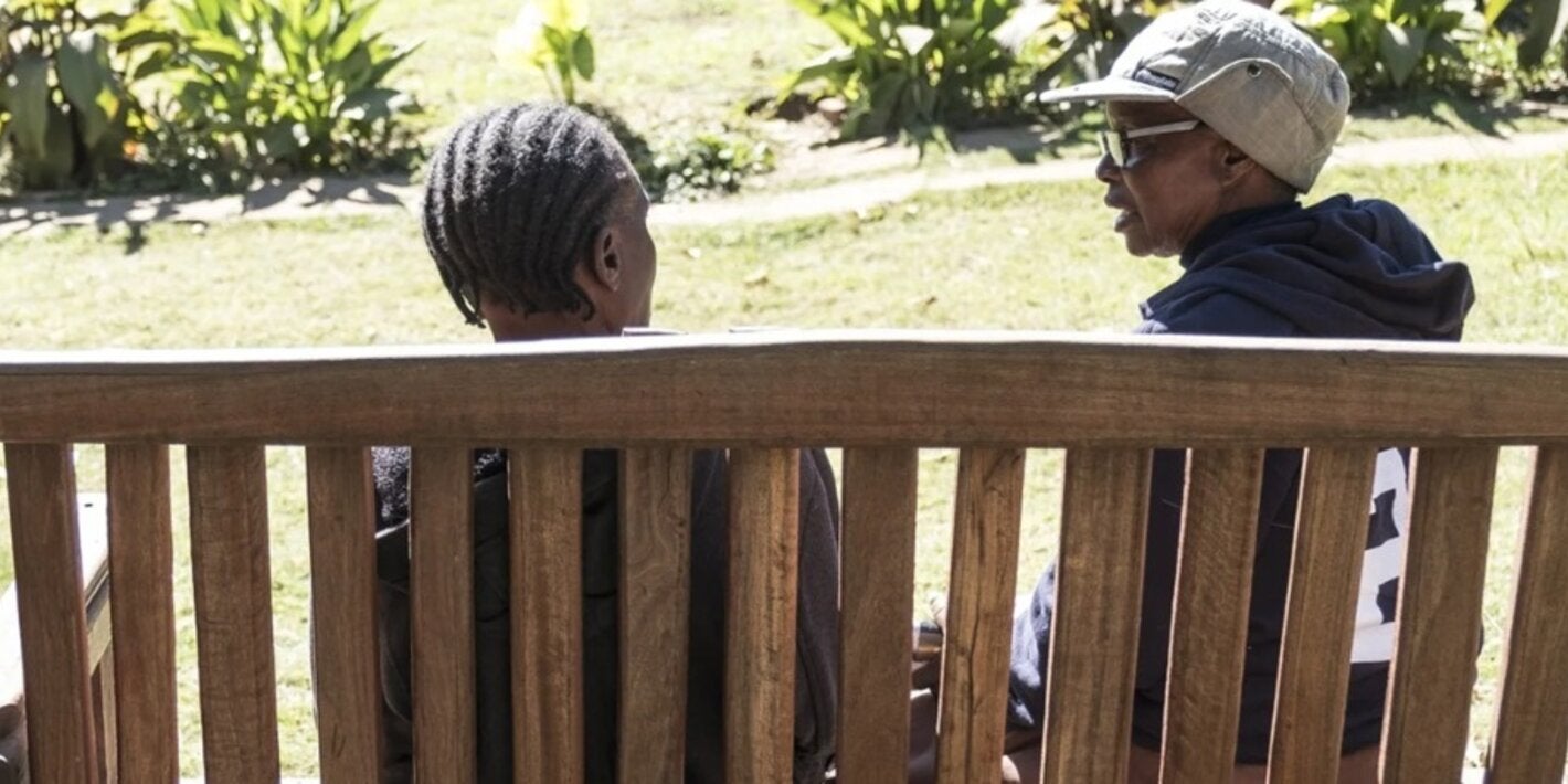 people seated in a bench talking