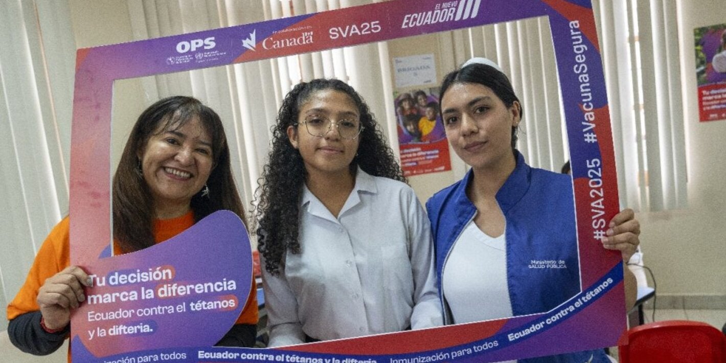 Sonia Quezada, representante de la Organización Panamericana de la Salud / Organización Mundial de la Salud (OPS/OMS) en Ecuador promueve la jornada de vacunación junto a una estudiante y una enfermera en el punto de vacunación desplegado en la Unidad Educativa “Manuela Cañizares”. 