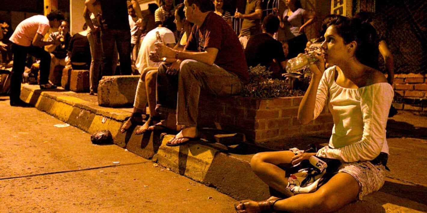 Grupo de jóvenes consumen bebidas alcohólicas en la vía pública