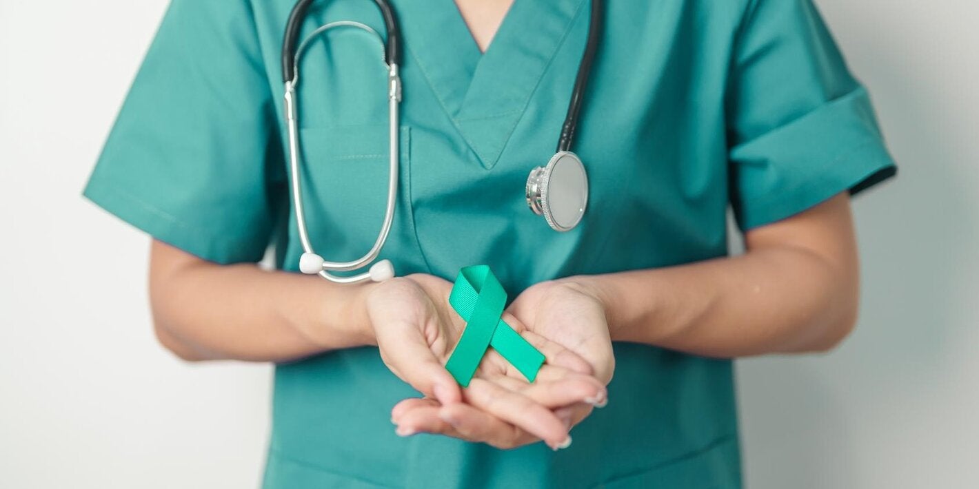 A female doctor with a teal shirt holds a teal ribbong in her hands. The human figure appears from the shoulders to the waist, as the hands are the important element in the picture
