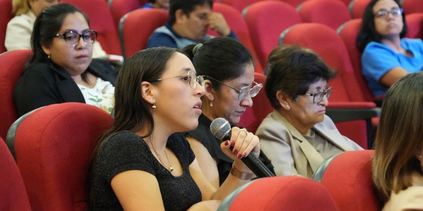 participante del taller sujeta el micrófono para tomar la palabra