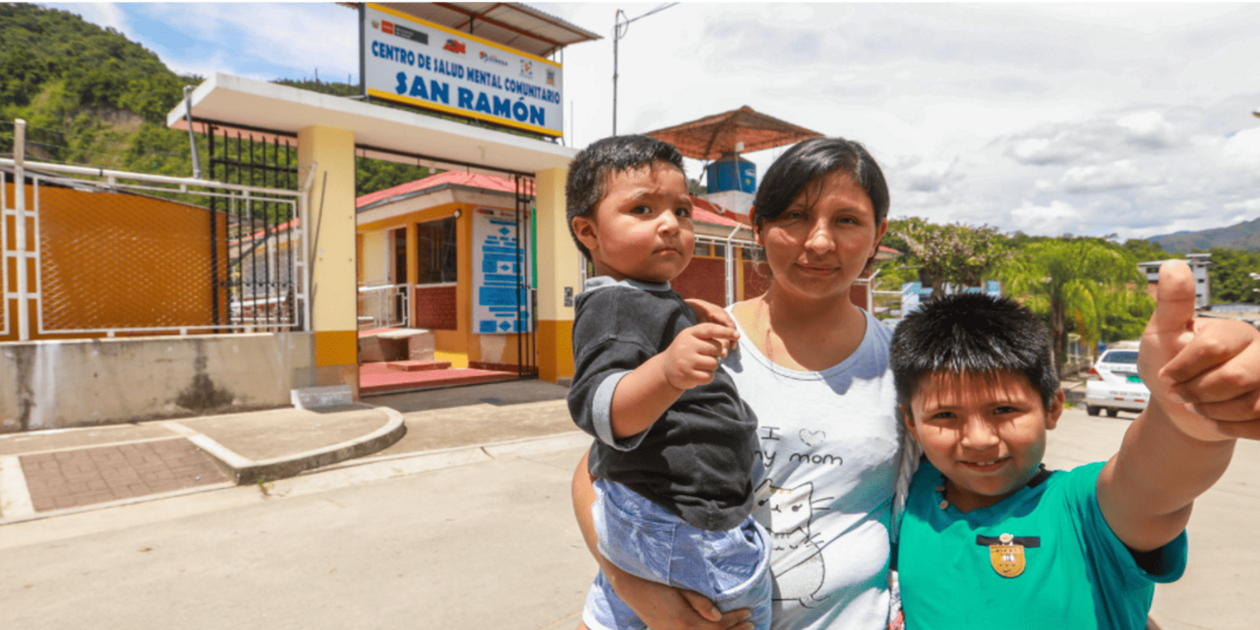 madre junto a sus niños en las afueras de un centro de salud mental comunitario