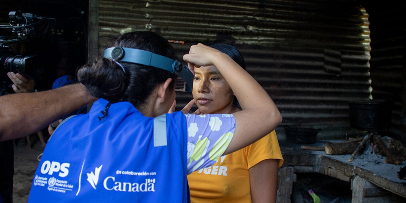 Mujer OPS analizando a una mujer de la comunidad