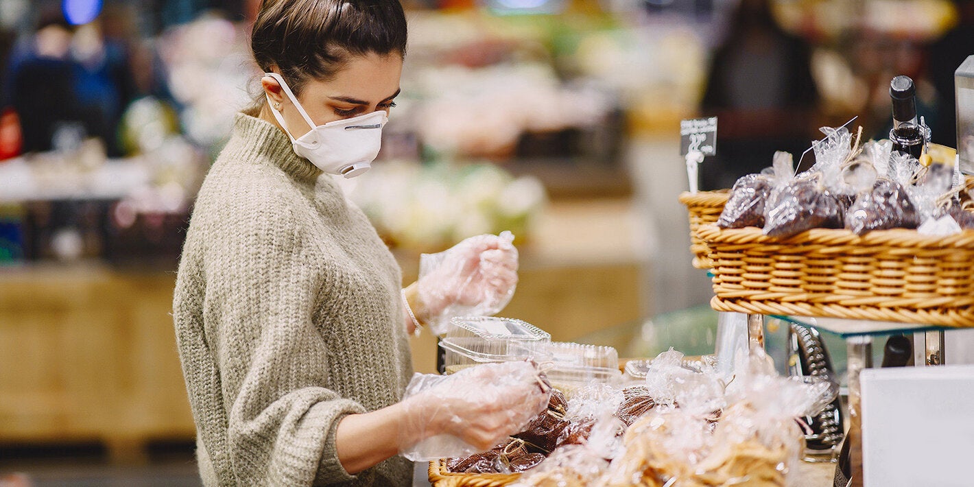 mulher de máscara fazendo compras