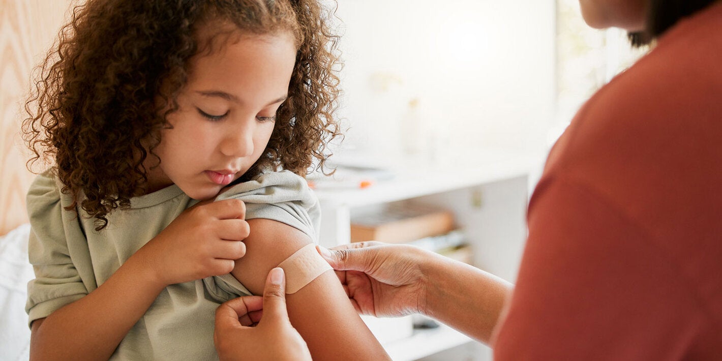 Girl gets a band aid after being vaccinated
