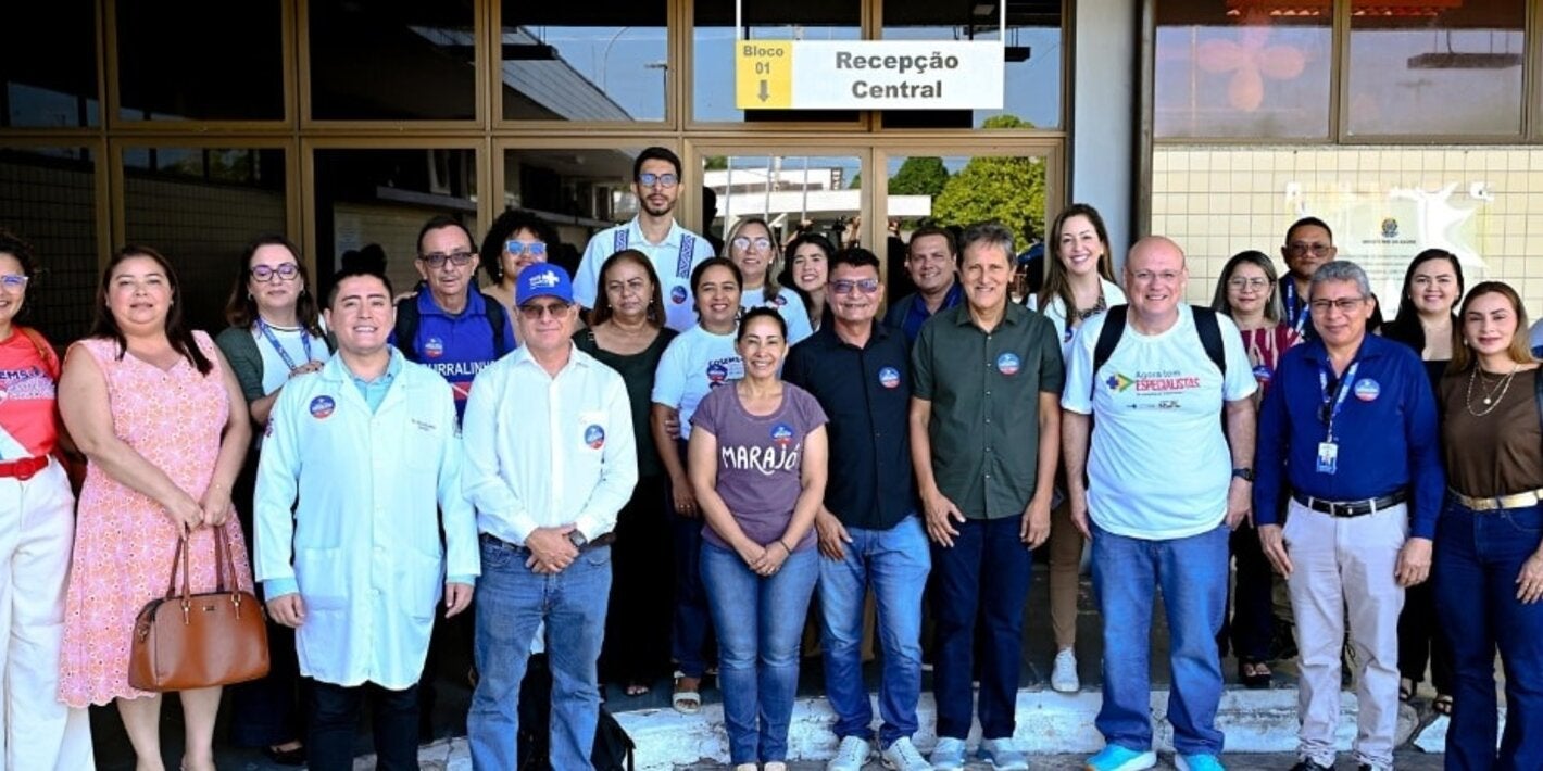 Representante da OPAS/OMS e autoridades nacionais e subnacionais do Brasil em frente a estabelecimento de saúde