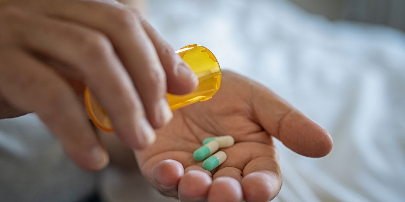 Woman holds antibiotics on her hand