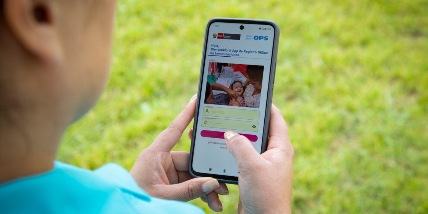 Person holding a mobile phone with immunization's application