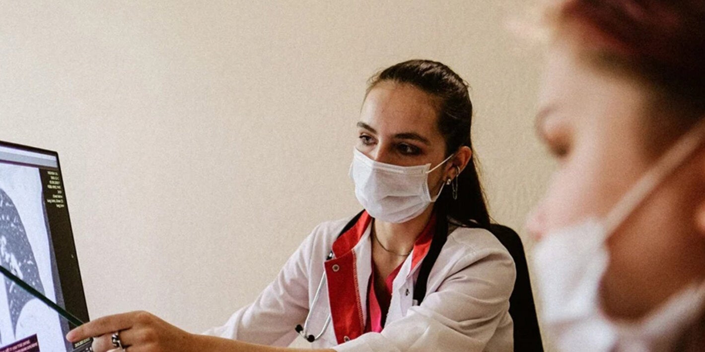 Médica mostrando resultado de exame de pulmão para paciente