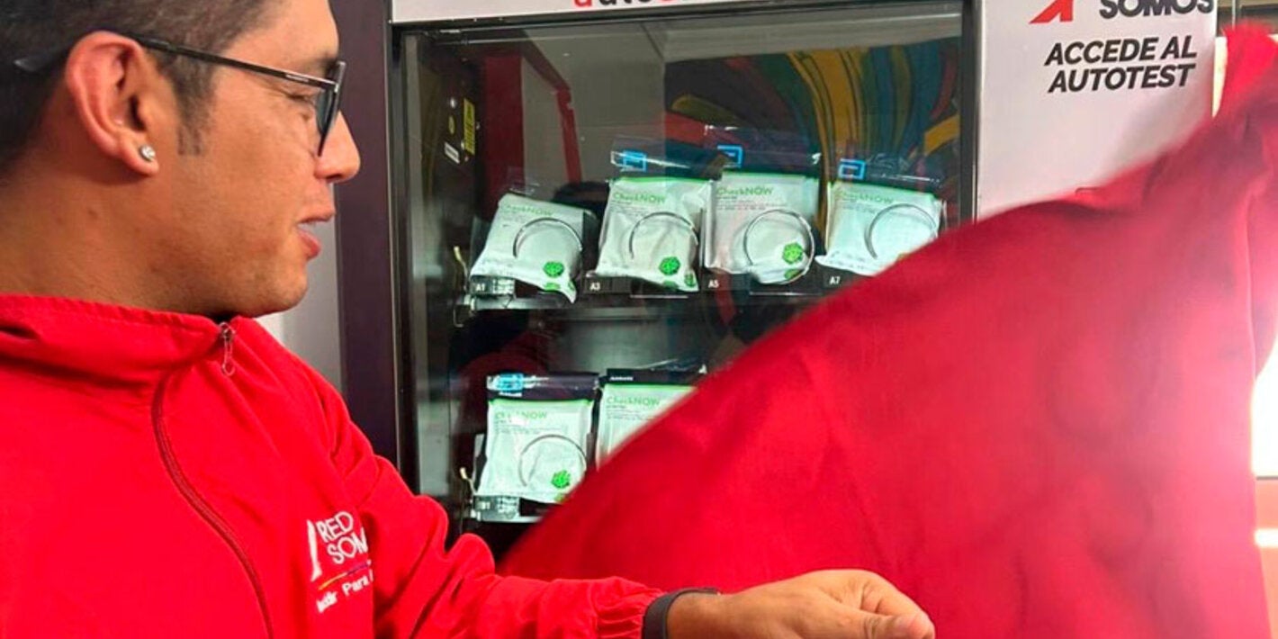 Personaje destapando maquina dispensadora de pruebas de tamizaje