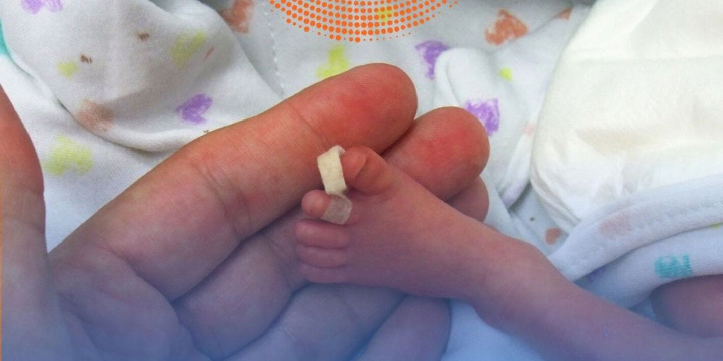 Foot of premature baby on a mother's hand