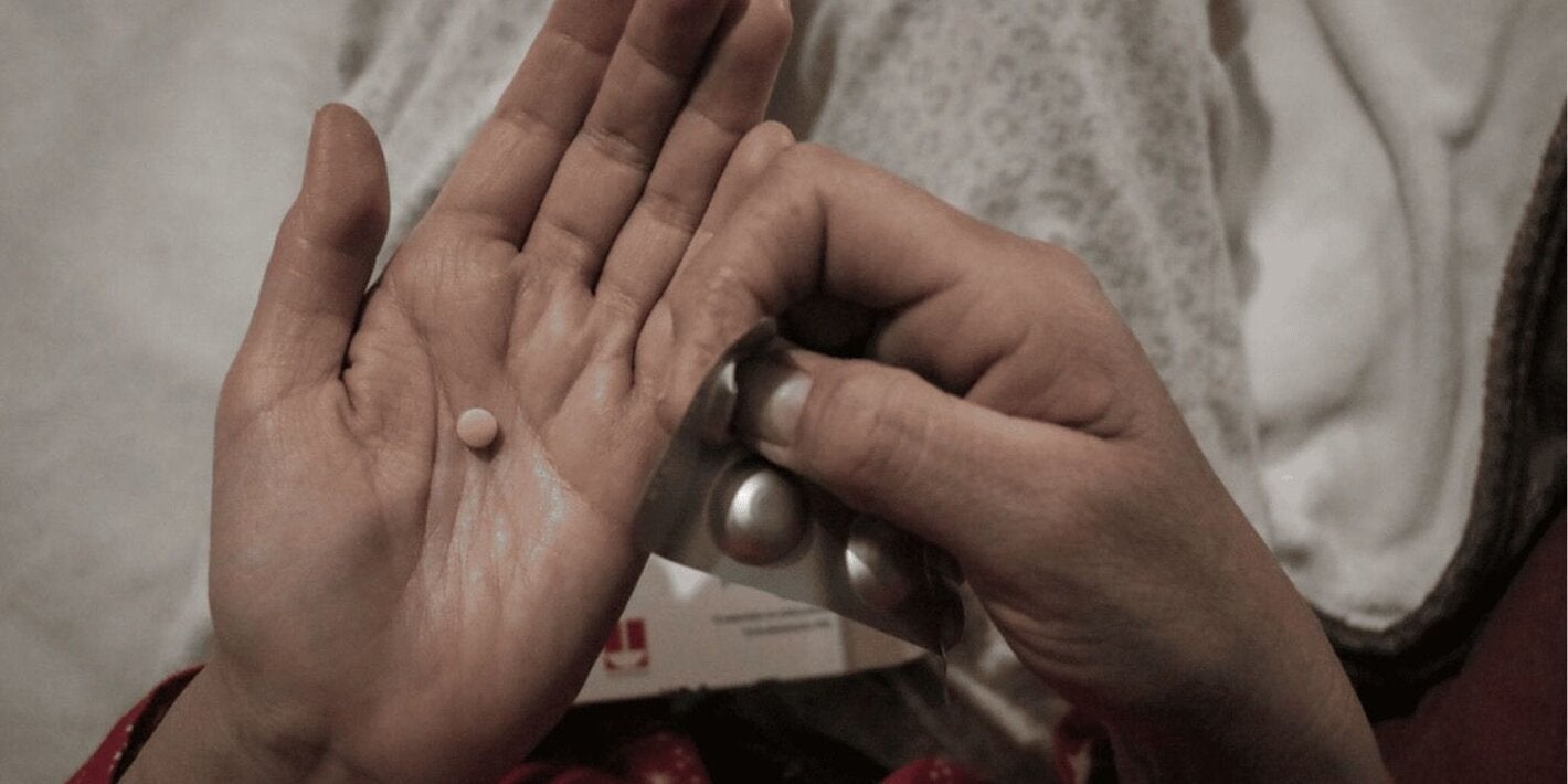 manos muestran un blíster de medicamentos