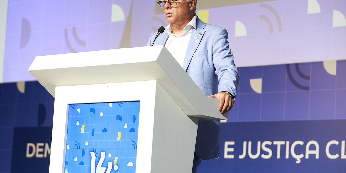Representante da OPAS, vestido com terno azul claro, fala no púlpito durante abertura do Abrascão