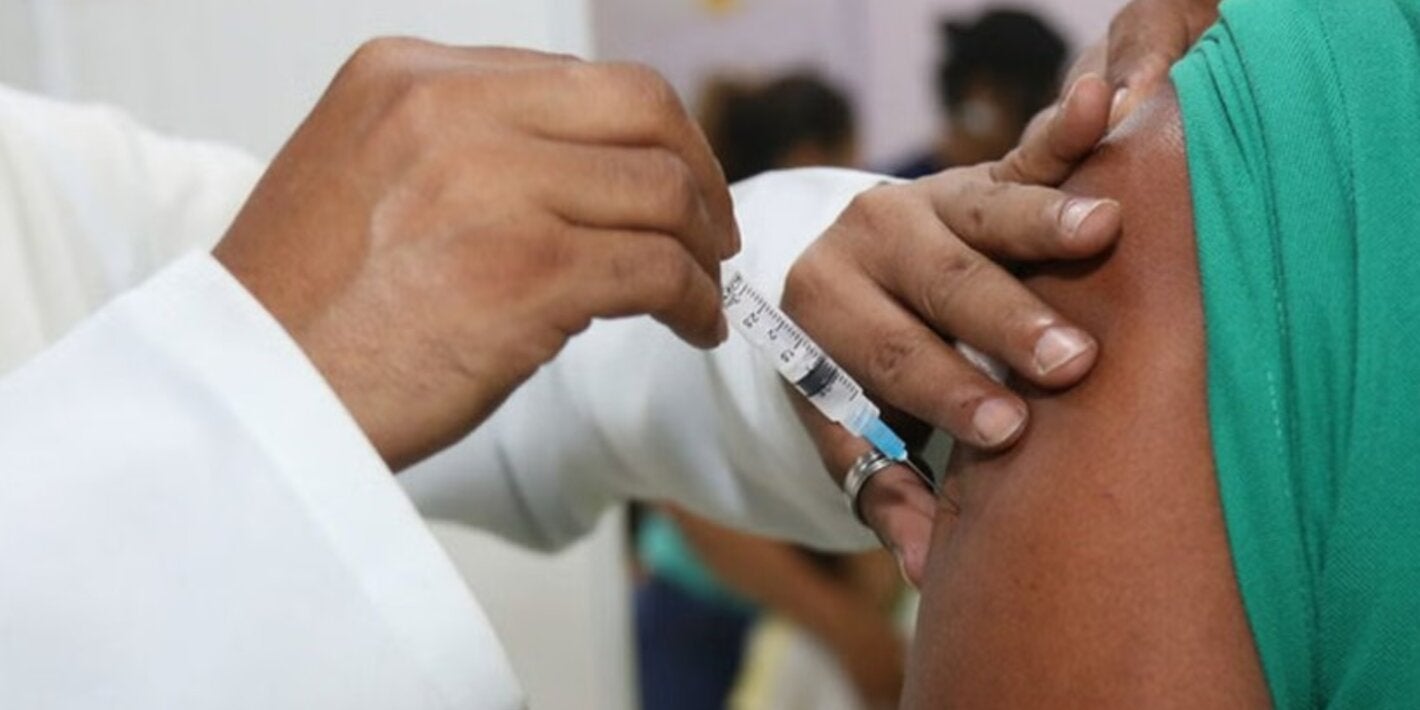 Profissional de saúde vacinando paciente