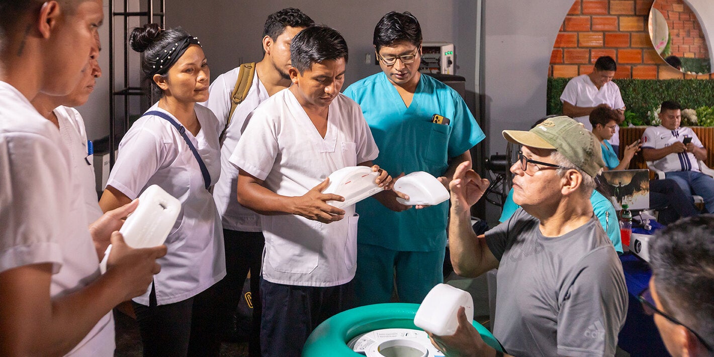 Personal de salud practica cómo colocar los paquetes congelantes en la caja fría pasiva de larga duración.