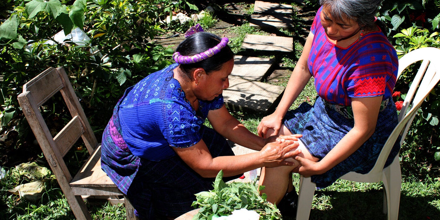 Terapeuta maya da un masaje a mujer q'anjob'al