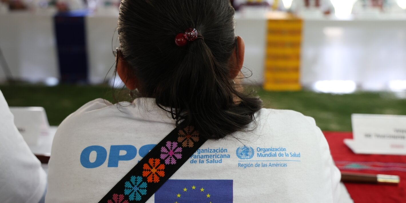 Mujer de espalda participando en reunión sobre salud materna