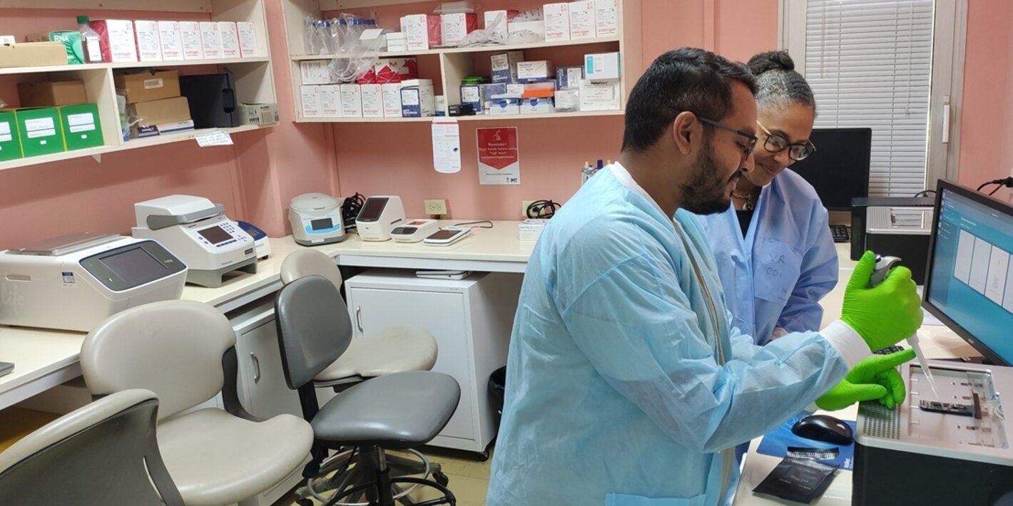 A lab technician and Professor Christine Carrington, Professor of Molecular Genetics and Virology in the lab at the UWI.