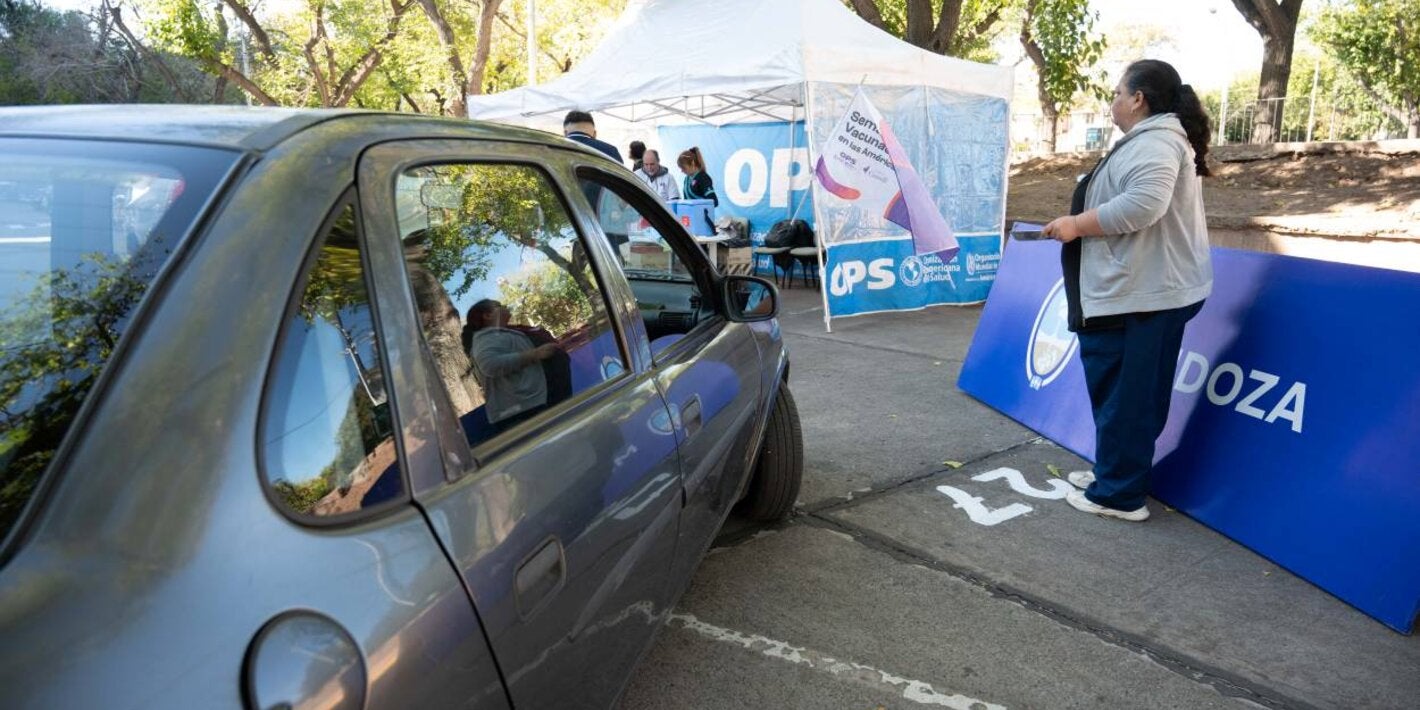 Un automóvil ingresa al dispositivo de vacunación. A lo lejos se divisa el gazebo de la Organización Panamericana de la Salud
