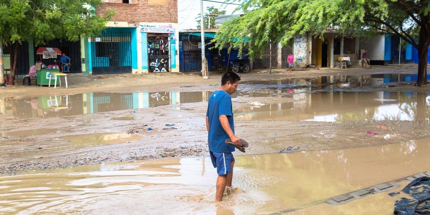 hombre en medio de un charco de agua provocada por las lluvias