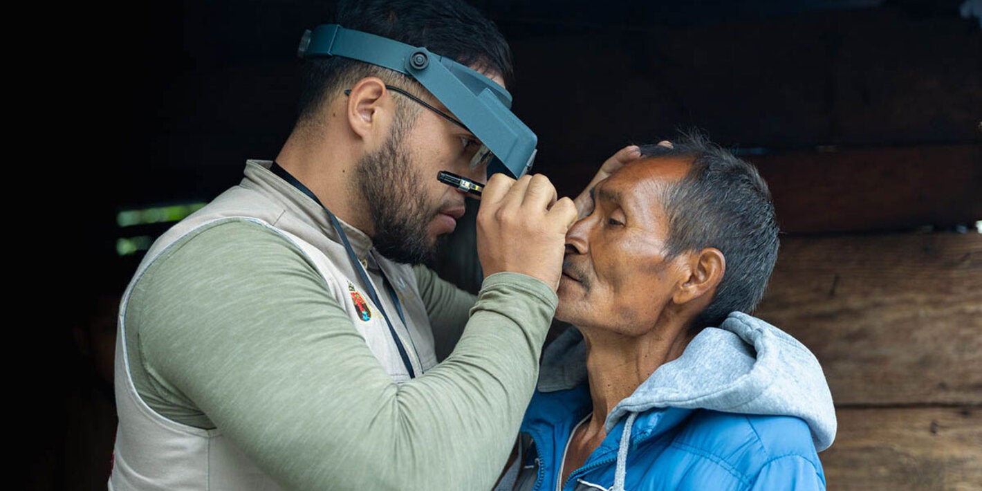 Health worker checks patient's eyes