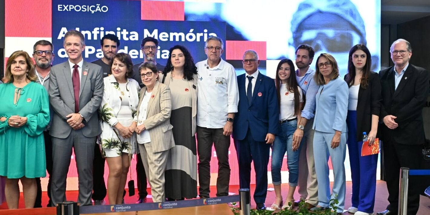 Autoridades, investigadores y representantes de instituciones asociadas y de la sociedad civil posan para una fotografía durante la ceremonia de inauguración de la exposición itinerante “La Infinita Memoria de la Pandemia”, realizada en Brasilia, Distrito Federal. Están presentes el Ministro de Salud de Brasil, Alexandre Padilha, y el Representante de la OPS en Brasil, Cristian Morales, junto a integrantes de los equipos del Memorial Digital de la Pandemia de COVID-19. Al fondo, una pantalla digital exhibe 