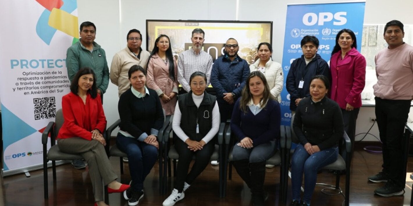 participantes de taller posan para foto junto a banners del evento