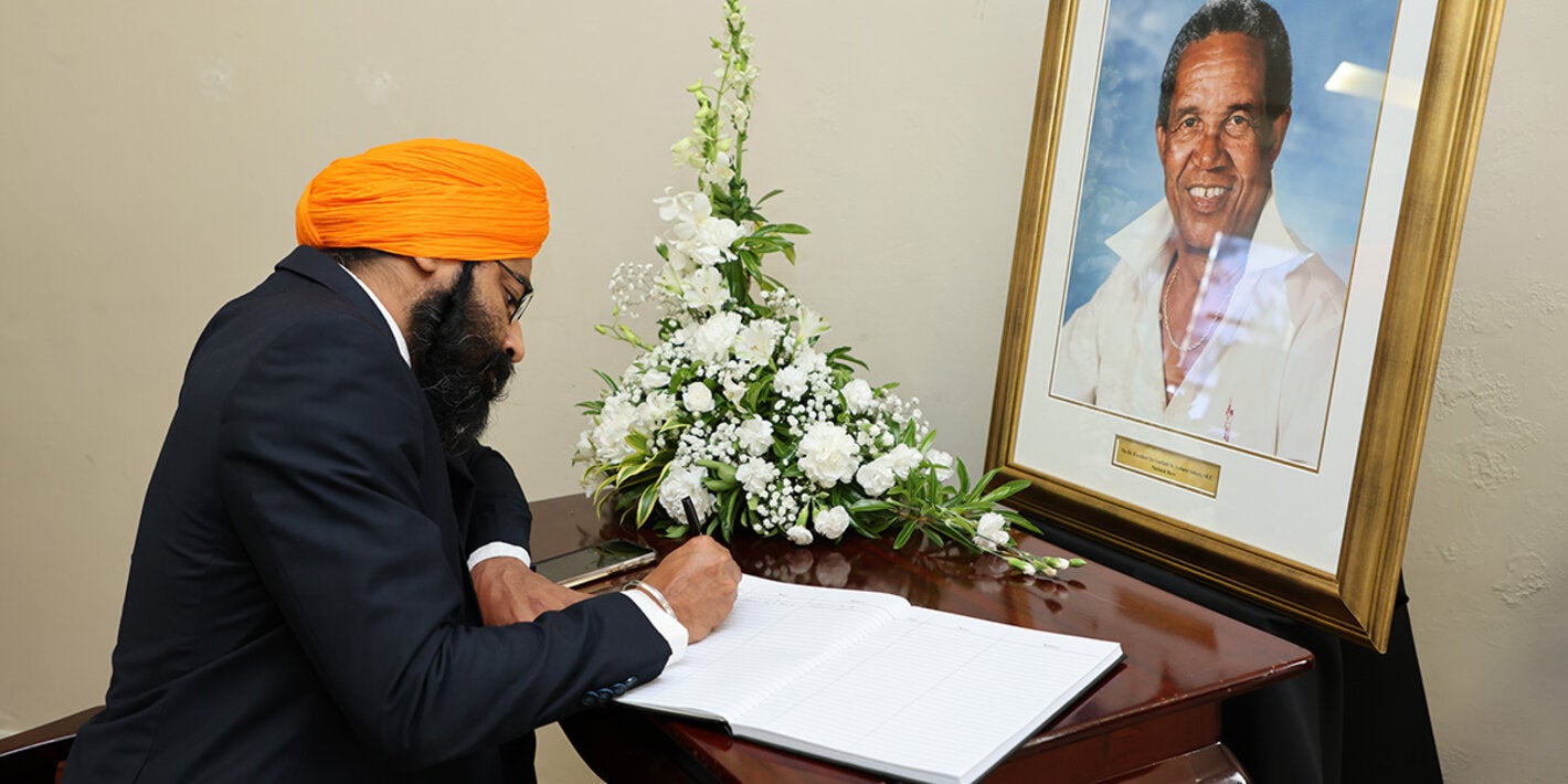 Dr. Prabhjot Singh signs Sir Garfield Sober's condolence book on behalf of PAHO/WHO
