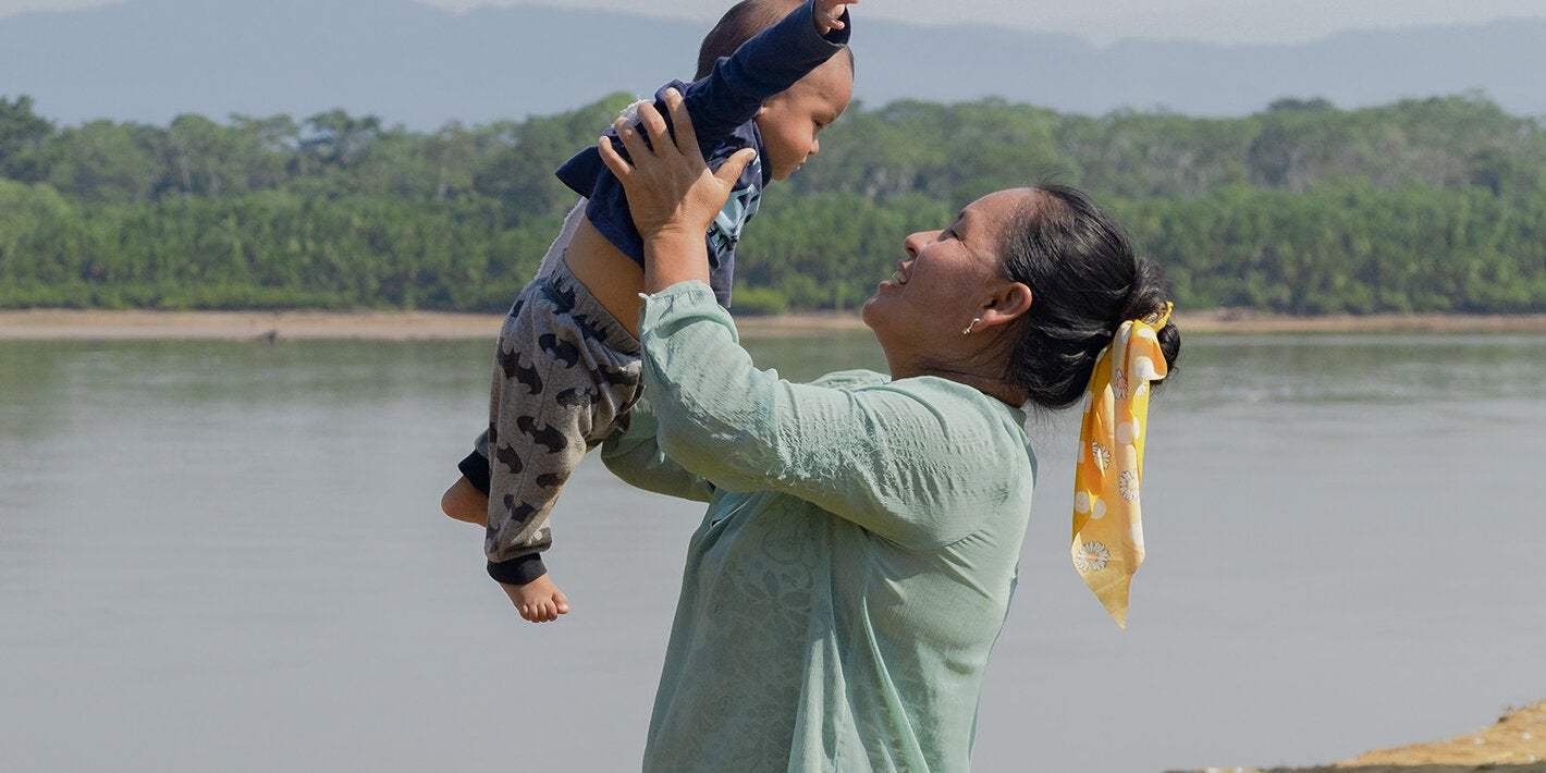 Madre cargando a hijo en el Amazonas
