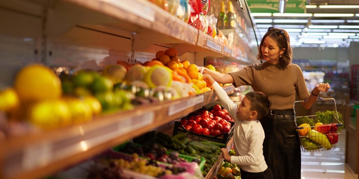 Madre ehijo compran frutas y verduras en un super mercado