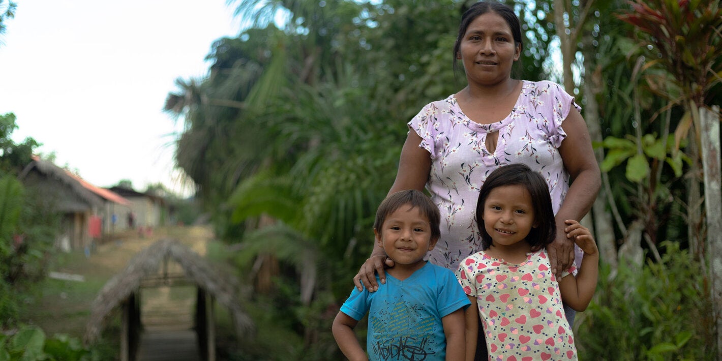 A mother in the Amazon with her smiling daughter and son