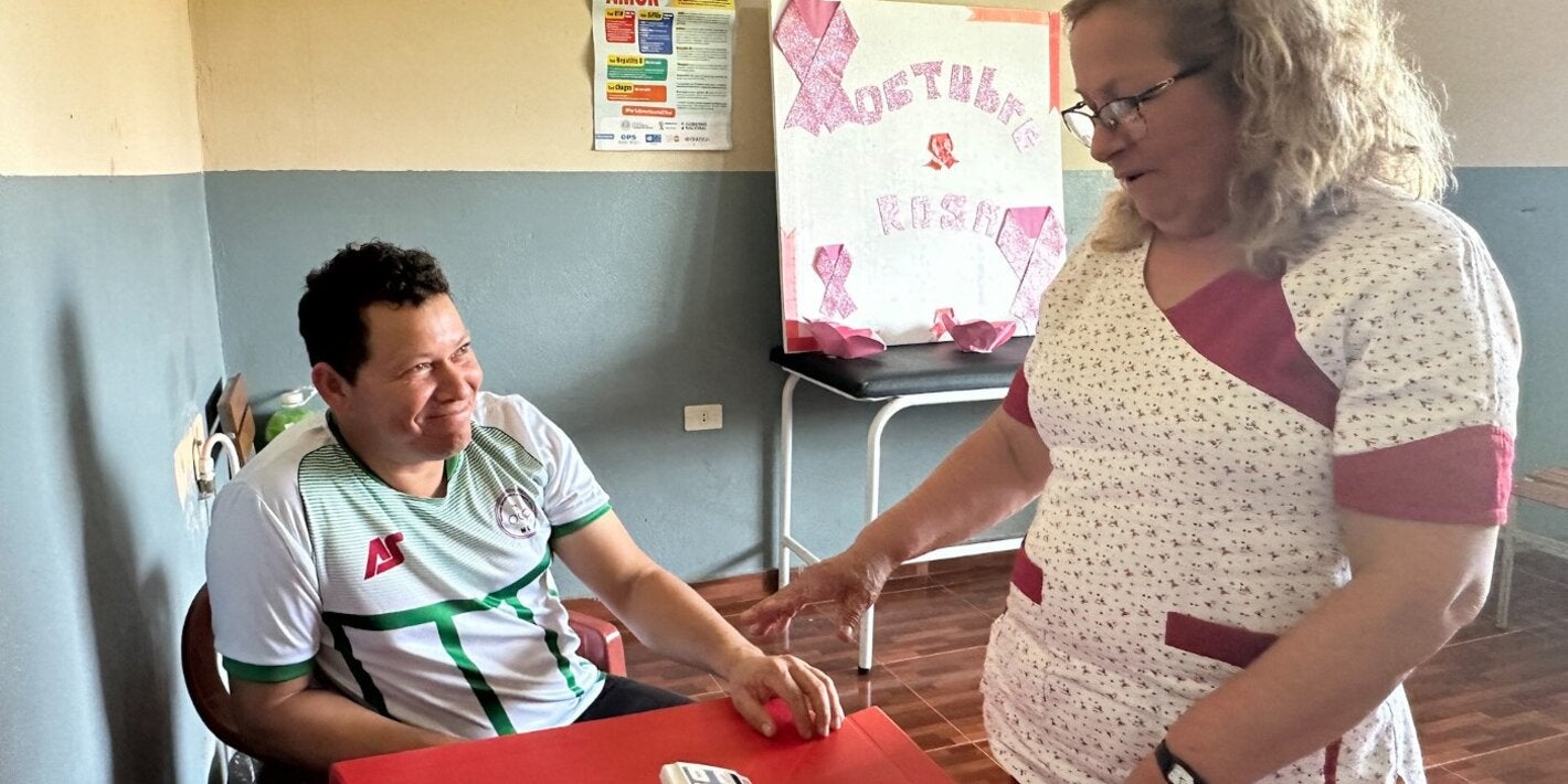 A healthcare worker measures and records a community member’s blood pressure at a health facility in Paraguay.